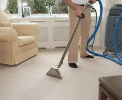 Carpet cleaning professional removing dirt and stains with a hot-water extraction tool in a home, Arlington, TX.