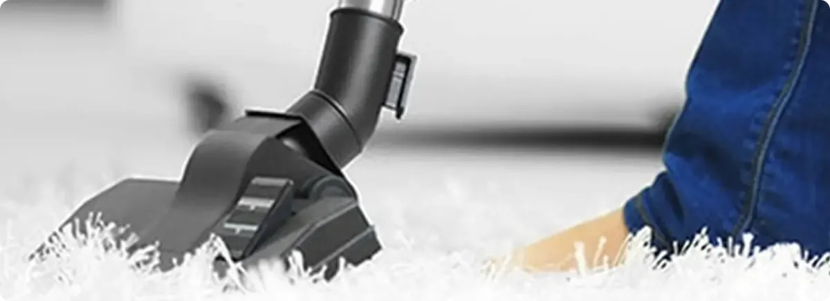 Close-up of a professional vacuuming a white carpet in Haltom City.